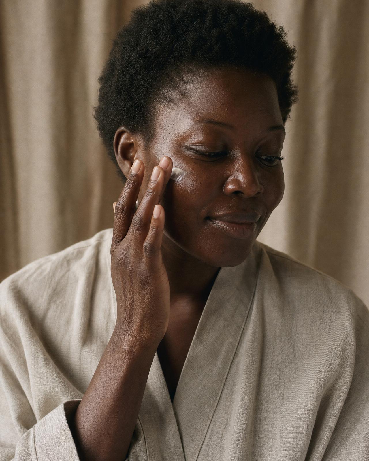 Portrait éditorial d'une femme à la peau ébène radieuse, entourée de fleurs d'hibiscus